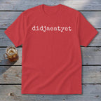 Red t-shirt with white text "didjaeatyet" on a wooden background.
