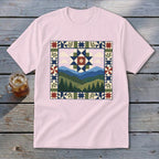 Pink t-shirt with a mountain landscape quilt-style graphic featuring trees and a star pattern.