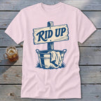 Pink t-shirt with a graphic of a sign reading "RID UP" over a bucket of laundry.