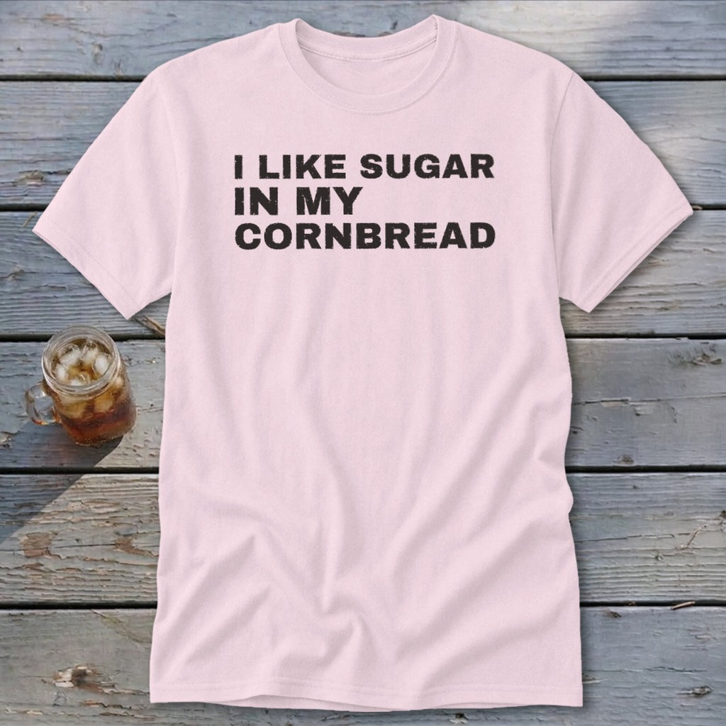 Pink t-shirt with black text "I LIKE SUGAR IN MY CORNBREAD" and a glass of iced tea.