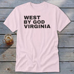 Light pink t-shirt with black text reading "WEST BY GOD VIRGINIA".