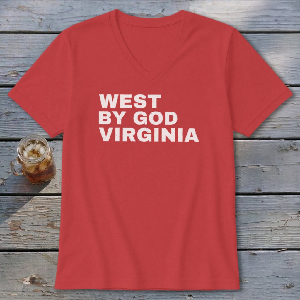 Red v-neck t-shirt with white "WEST BY GOD VIRGINIA" text and a drink on a wooden table.