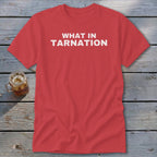 Coral t-shirt with white text reading "WHAT IN TARNATION" and a glass of iced tea.