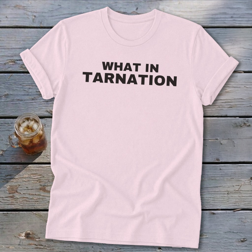 Light pink t-shirt with "WHAT IN TARNATION" printed in black text.