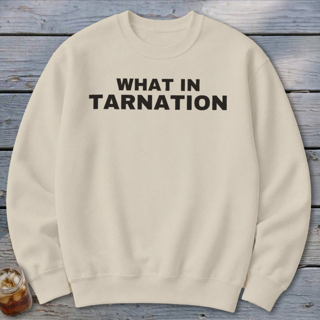 Cream sweatshirt with black text reading "WHAT IN TARNATION".