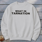 White crewneck sweatshirt with black text reading "WHAT IN TARNATION".