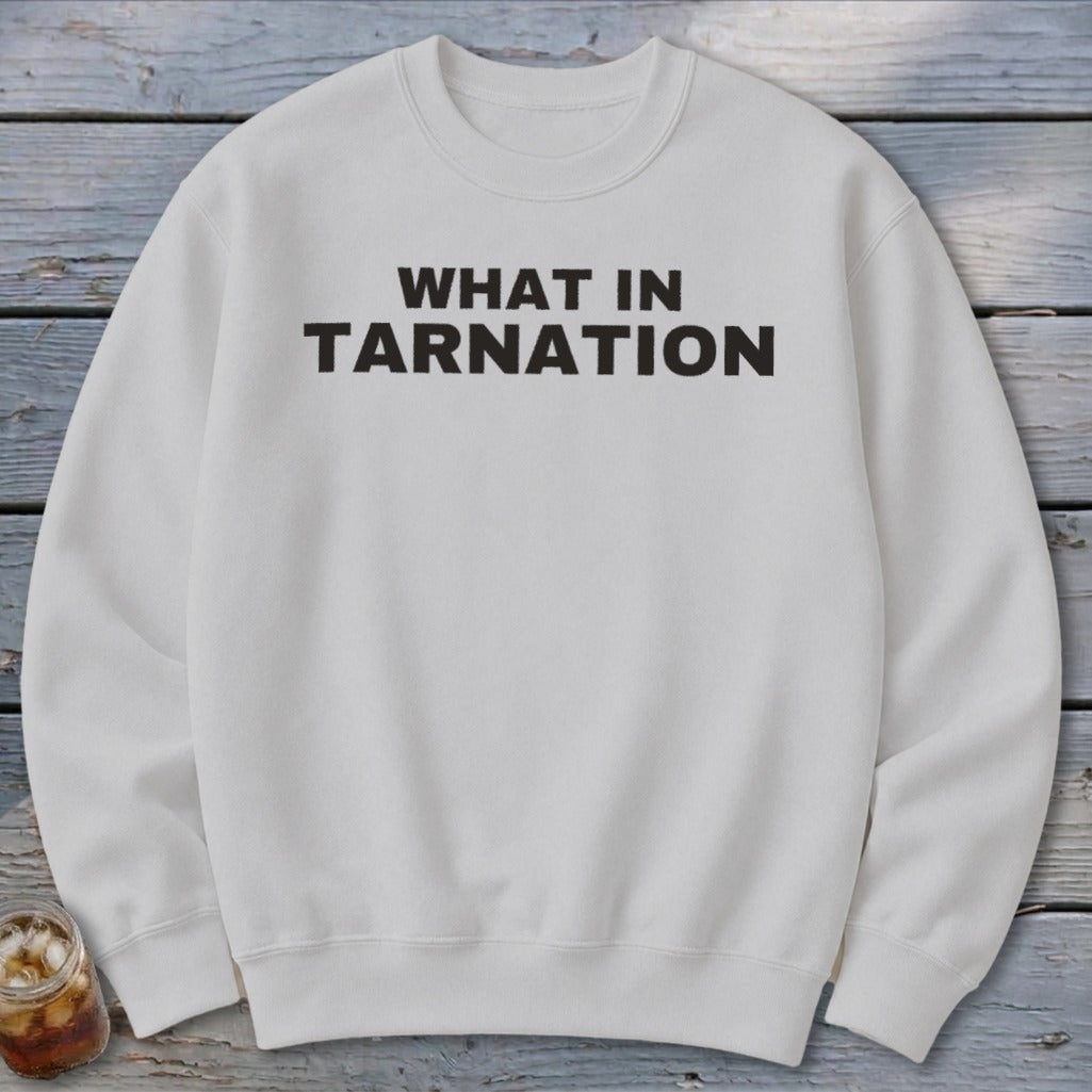 White crewneck sweatshirt with black text reading "WHAT IN TARNATION".