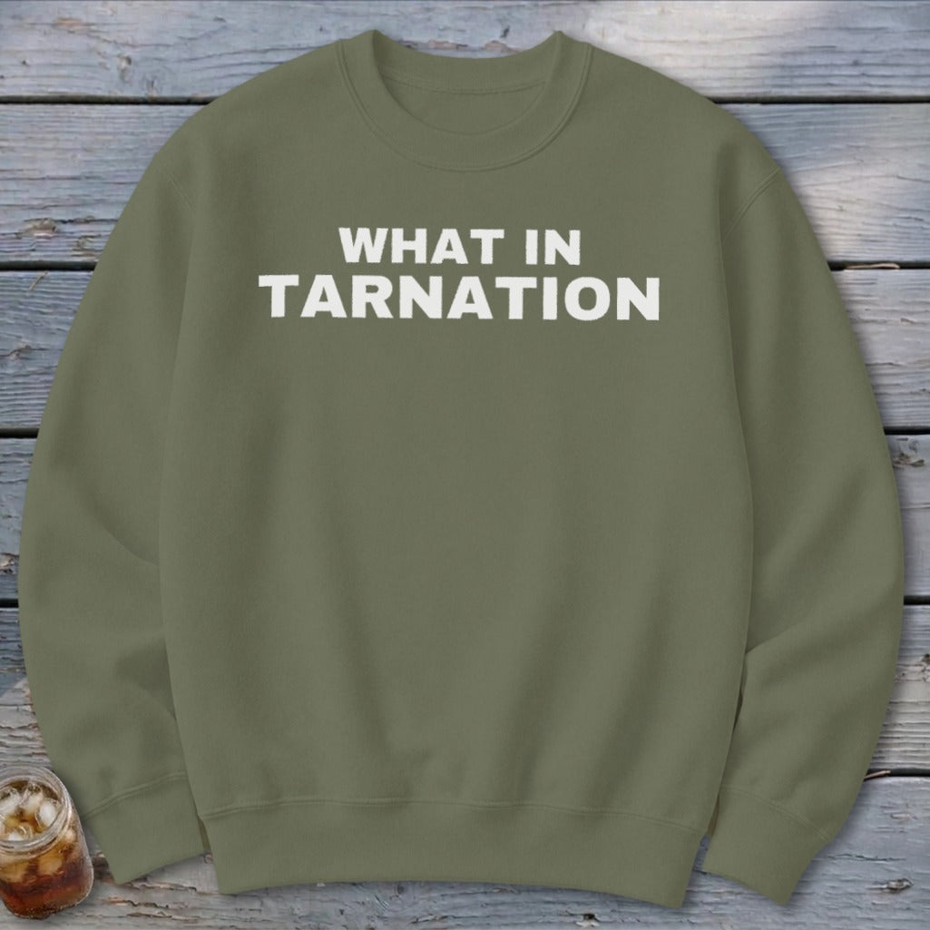 Olive green sweatshirt with "WHAT IN TARNATION" printed in white text.