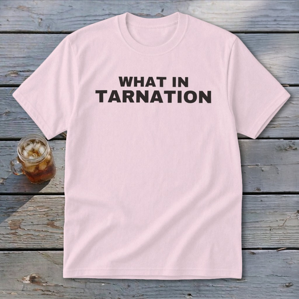 Pink t-shirt with black text "WHAT IN TARNATION" next to a glass of iced tea.