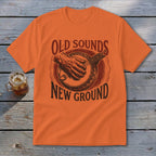 An orange t-shirt featuring a retro graphic of a banjo player and text reading Old Sounds New Ground.