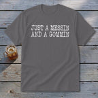 Gray t-shirt with white text "JUST A MESSIN AND A GOMMIN" and a glass of iced tea.