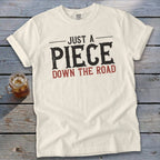 Cream Comfort Colors t-shirt with "JUST A PIECE DOWN THE ROAD" text.