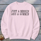 Pink crewneck sweatshirt with black text reading "JUST A MESSIN AND A GOMMIN".