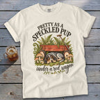 Cream t-shirt with "Pretty as a Speckled Pup under a red wagon" text and dog art.