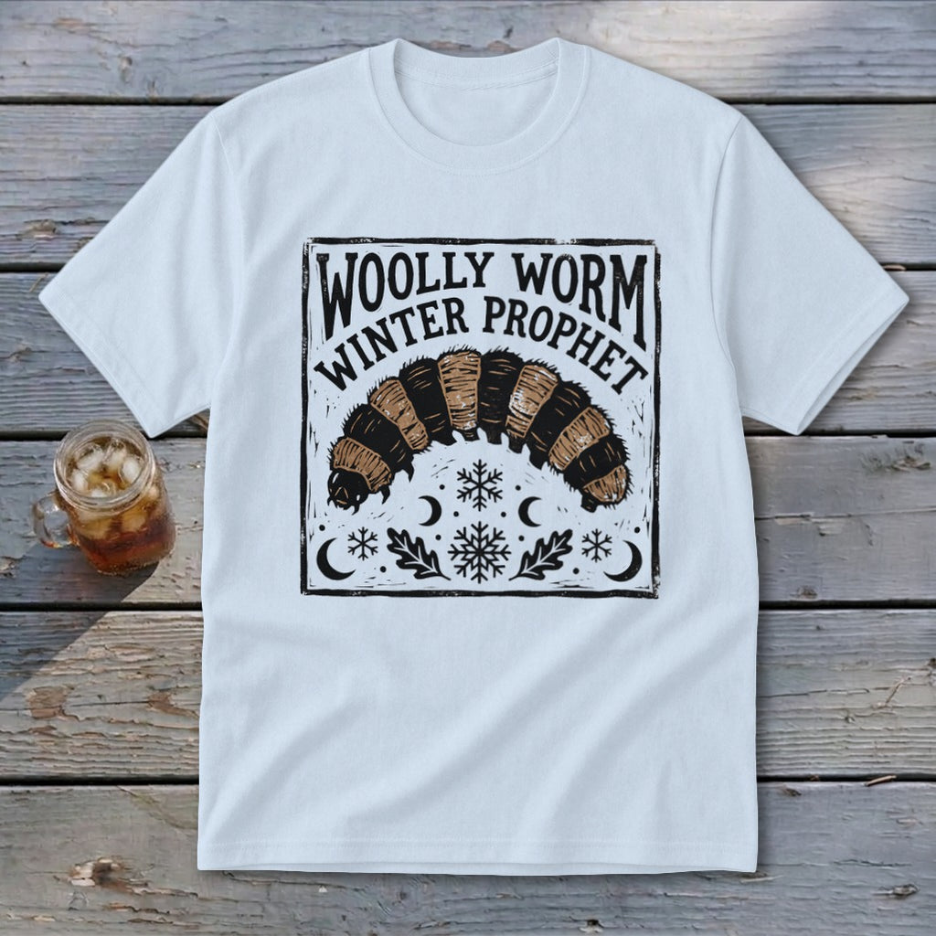 A white t-shirt featuring a graphic of a woolly worm caterpillar, snowflakes, and the text Woolly Worm Winter Prophet.