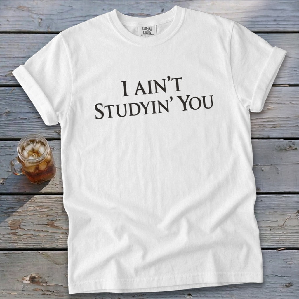 White Comfort Colors t-shirt with black text "I AIN'T STUDYIN' YOU".