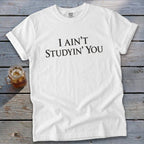 White Comfort Colors t-shirt with black text "I AIN'T STUDYIN' YOU".
