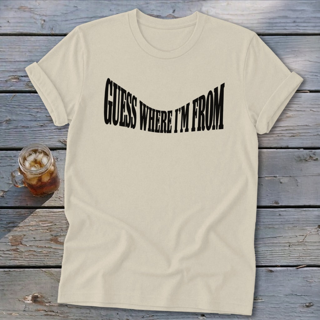 Cream t-shirt with black text reading "GUESS WHERE I'M FROM" in a wavy font.