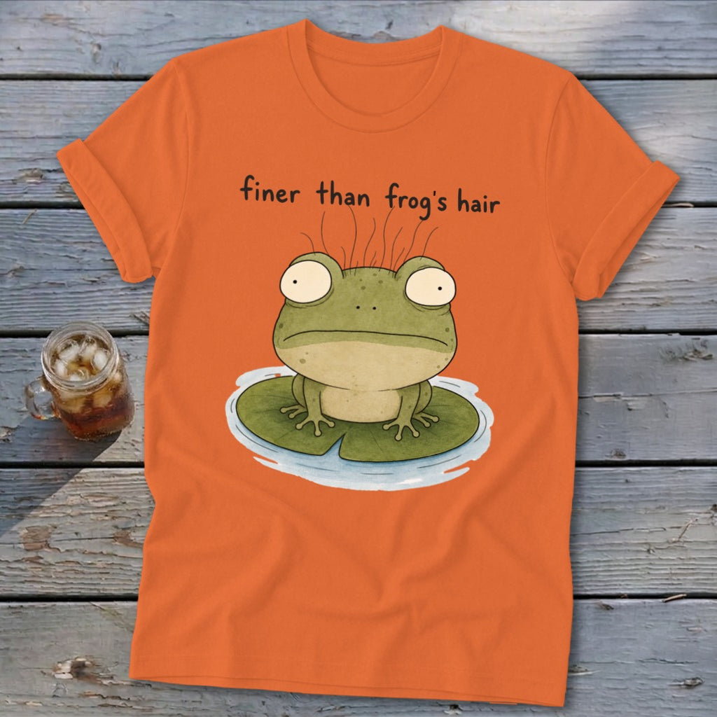 An orange t-shirt featuring a cartoon frog on a lily pad with the text finer than frog's hair.