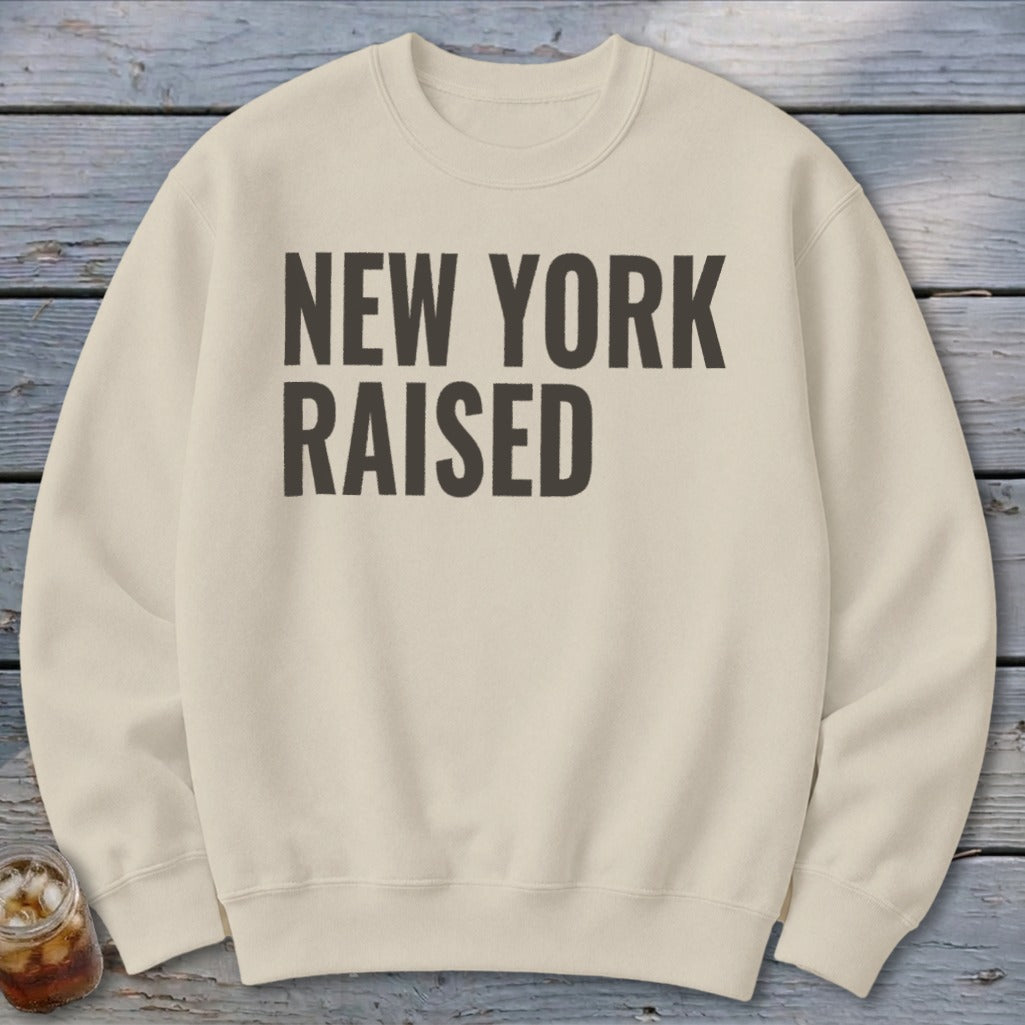 Cream sweatshirt with "NEW YORK RAISED" text in dark grey.