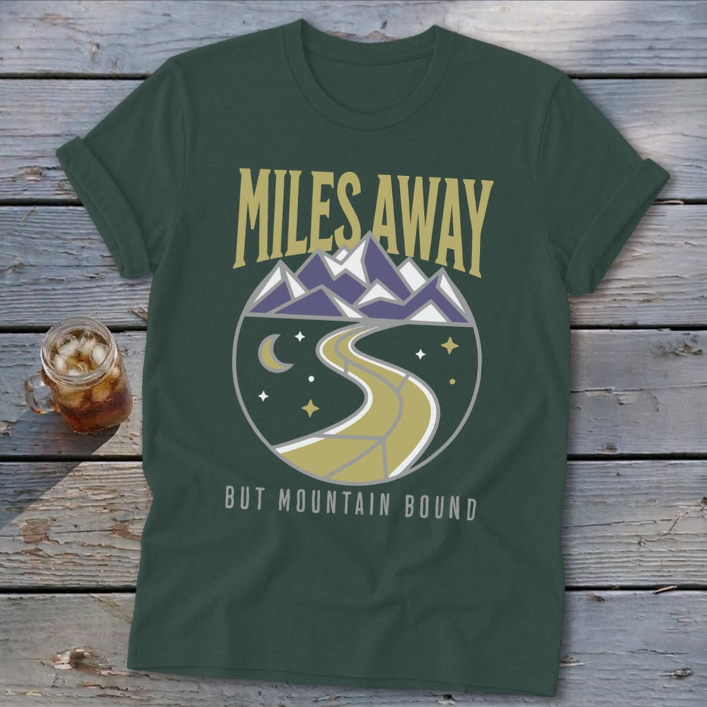Green t-shirt with "Miles Away But Mountain Bound" text and circular mountain graphic.