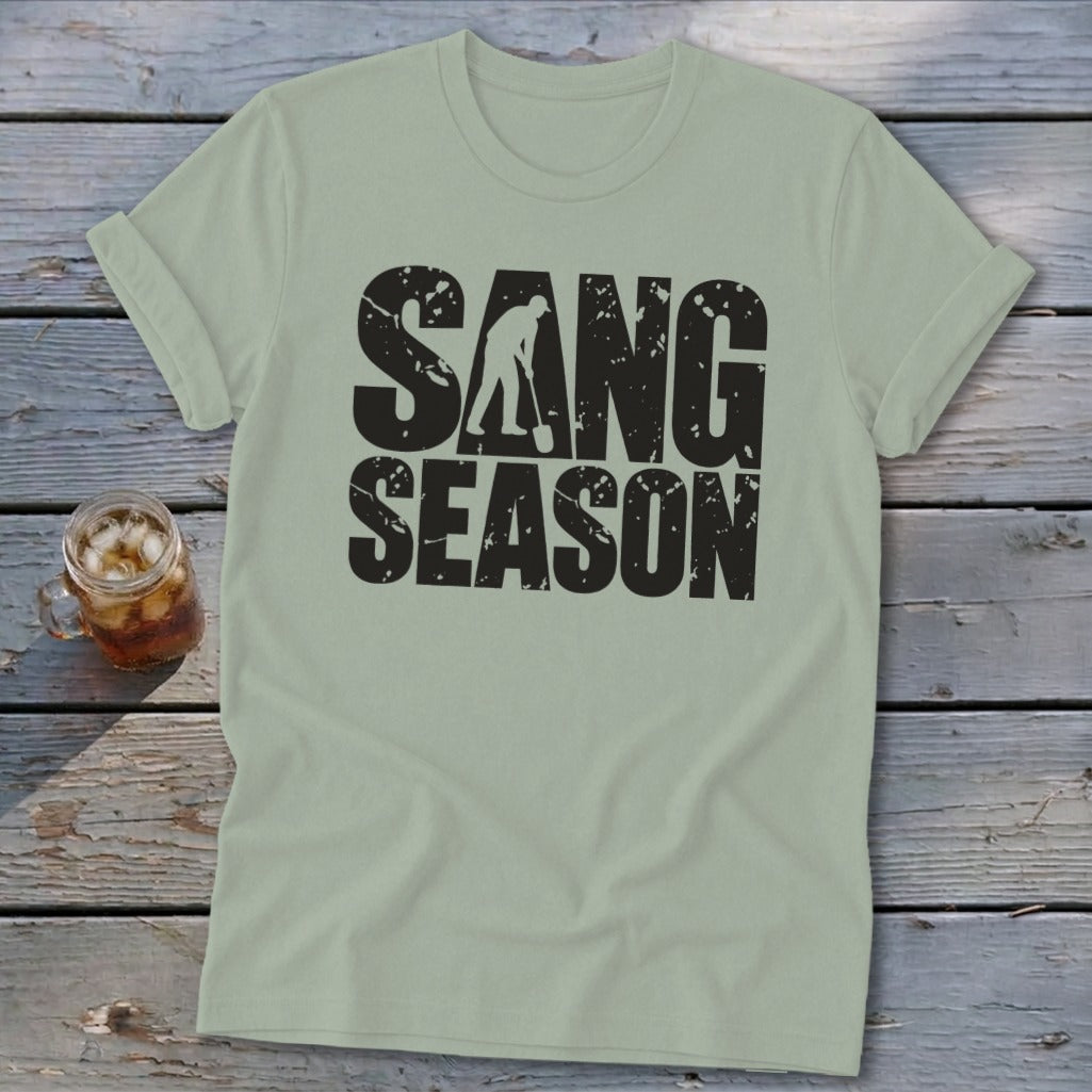 Sage green crewneck t-shirt featuring the distressed black text SANG SEASON and a silhouette of a person digging with a shovel.