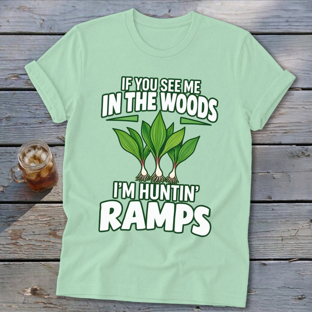 A light green t-shirt with text reading "IF YOU SEE ME IN THE WOODS I'M HUNTIN' RAMPS" and an illustration of ramps.