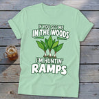 A light green t-shirt with text reading "IF YOU SEE ME IN THE WOODS I'M HUNTIN' RAMPS" and an illustration of ramps.