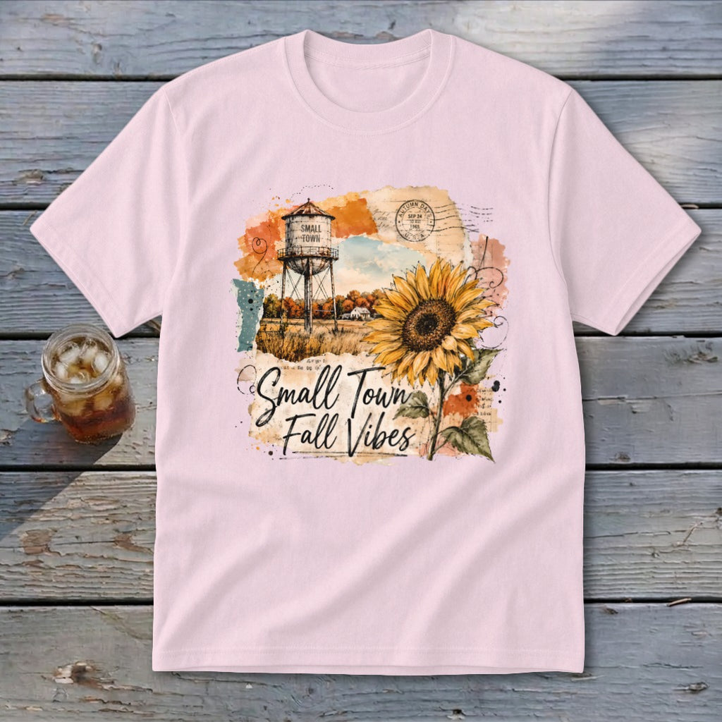 Pink t-shirt with "Small Town Fall Vibes" graphic featuring a sunflower and water tower.