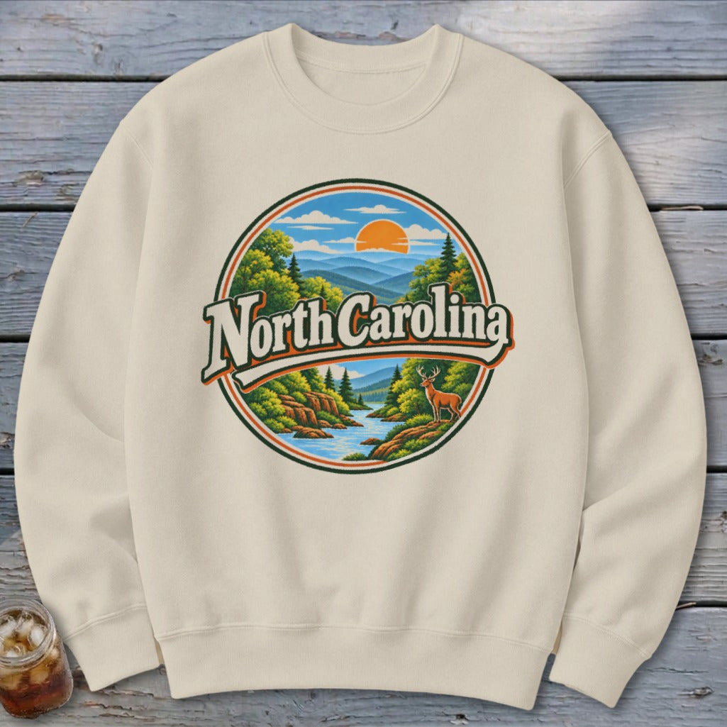 Cream sweatshirt with circular North Carolina mountain landscape graphic.