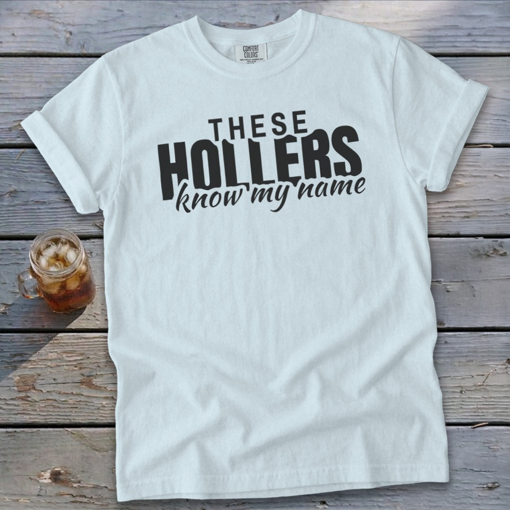White t-shirt with black text "THESE HOLLERS know my name"