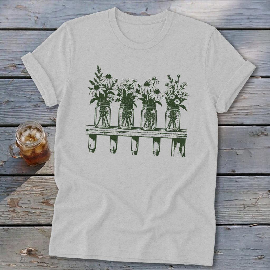 Light gray crewneck t-shirt featuring a green botanical illustration of four mason jars filled with wildflowers on a shelf.