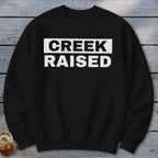 Black sweatshirt with "CREEK RAISED" printed in white on the chest.
