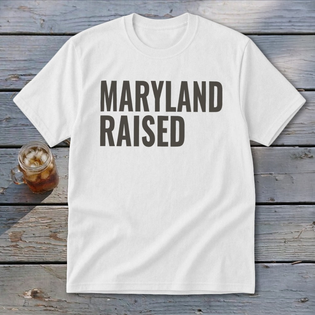 White t-shirt with dark gray text that reads "MARYLAND RAISED."