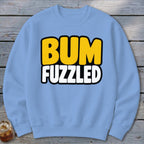 Light blue crewneck sweatshirt featuring the text BUM FUZZLED in bold yellow and white letters.