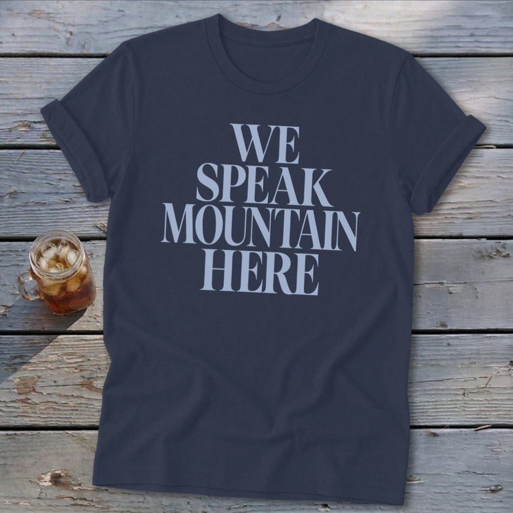 Navy t-shirt with "WE SPEAK MOUNTAIN HERE" text and a glass of iced drink.
