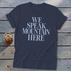 Navy t-shirt with "WE SPEAK MOUNTAIN HERE" text and a glass of iced drink.