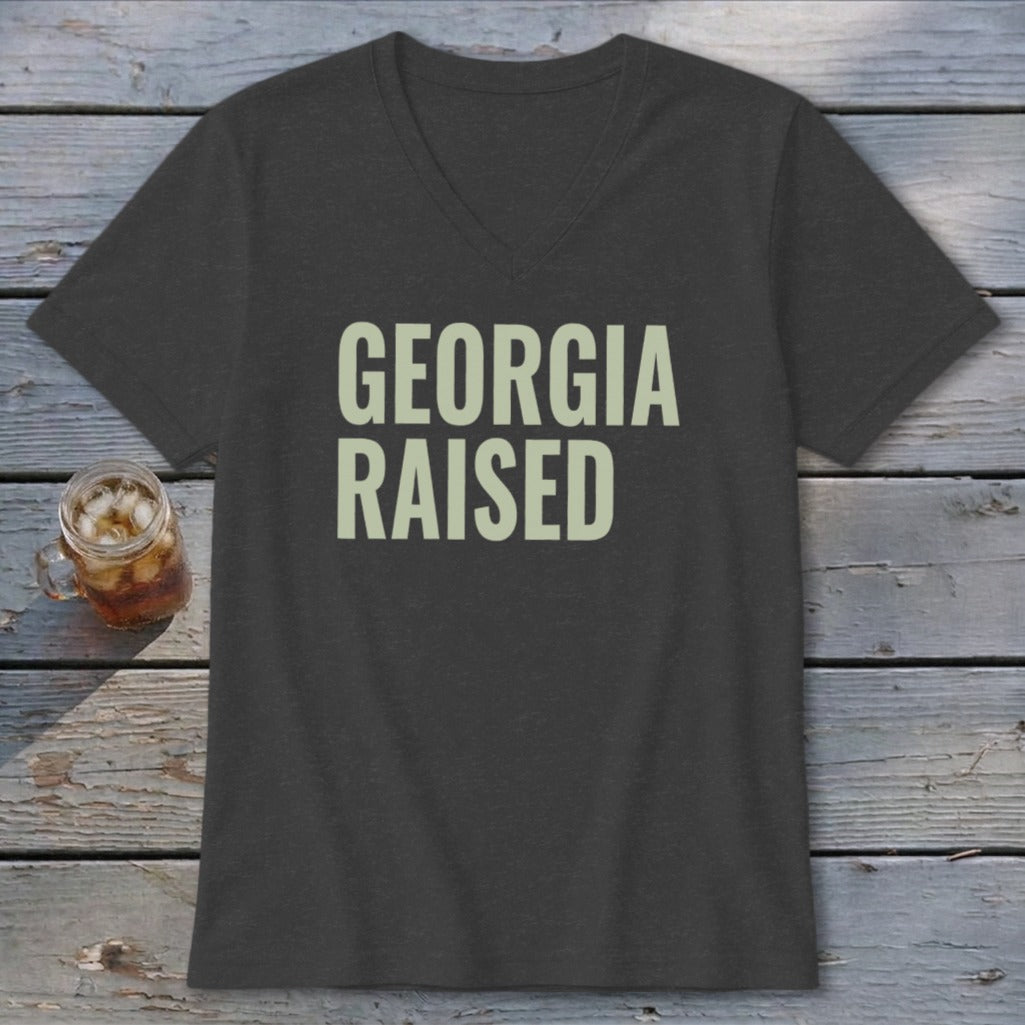 Dark grey v-neck t-shirt with "GEORGIA RAISED" in light green text.