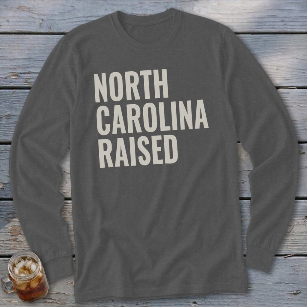 Dark grey long sleeve shirt with "NORTH CAROLINA RAISED" text in off-white.