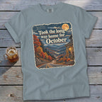 T-shirt with "Took the long way home for October" text and autumn mountain scene.