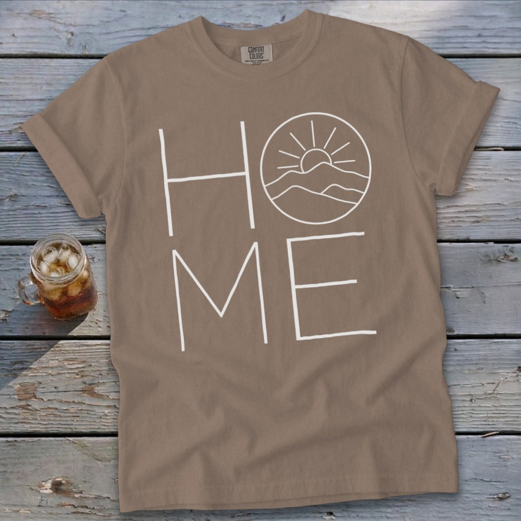 Brown t-shirt featuring the word HOME in white, with the O replaced by a sunrise mountain graphic.