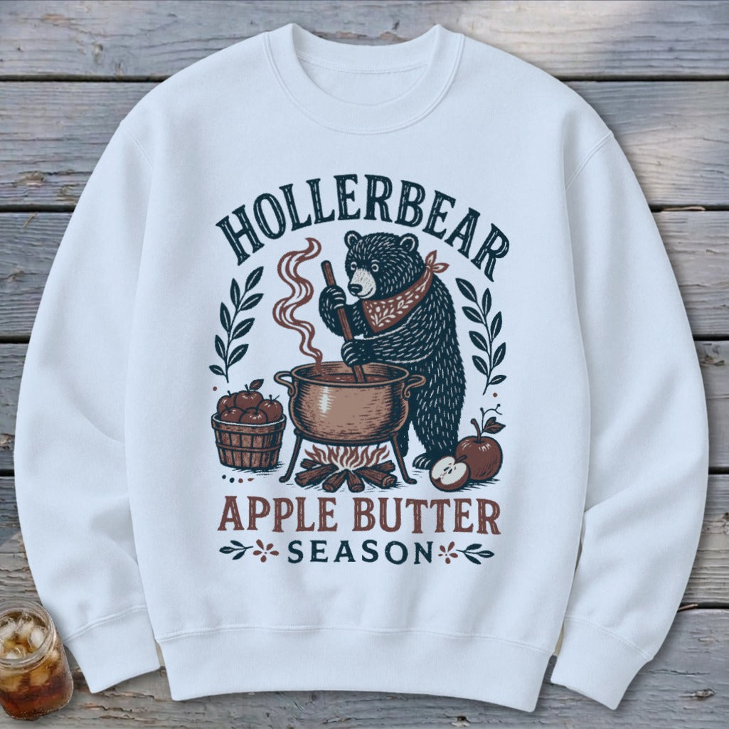 White sweatshirt with a bear making apple butter, text says "Hollerbear Apple Butter Season."
