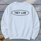 White crewneck sweatshirt with black oval graphic that says "THEY LAW".