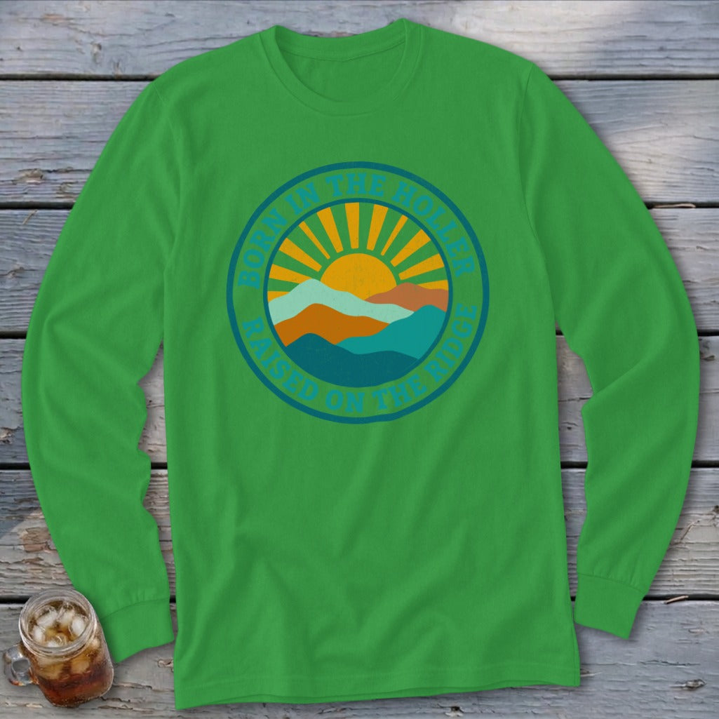 Bright green long-sleeve t-shirt with a round graphic of mountains, a sun, and text reading Born in the Holler Raised on the Ridge.