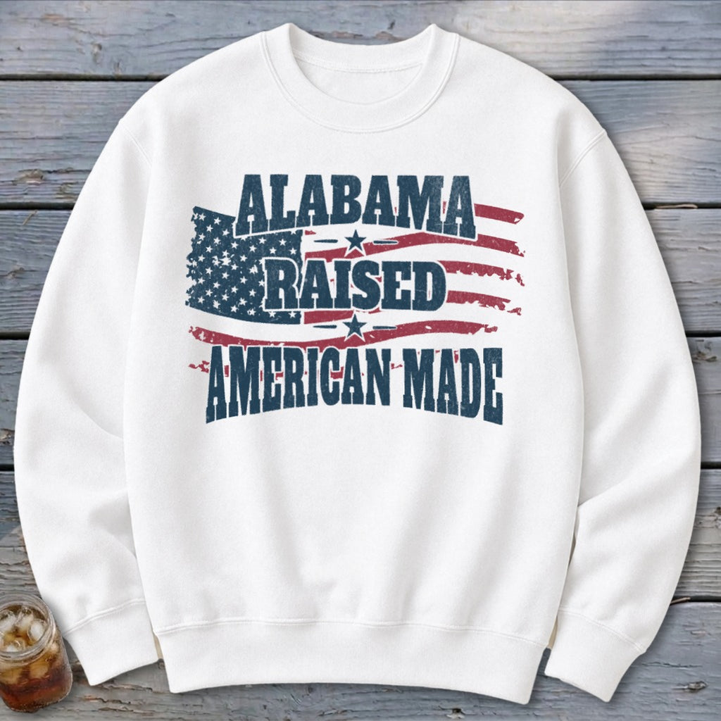 White sweatshirt with "Alabama Raised American Made" text and distressed American flag design.