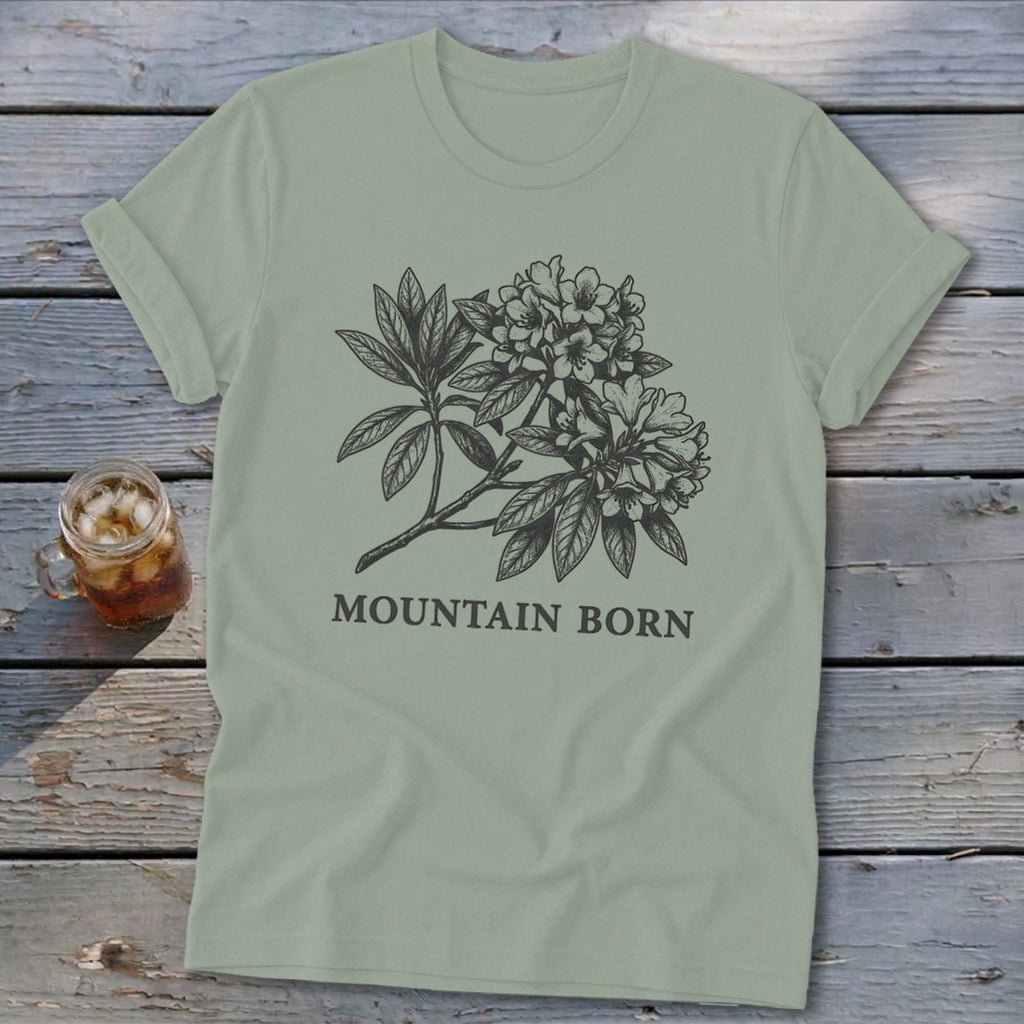 Sage green t-shirt with black rhododendron sketch and "MOUNTAIN BORN" text.