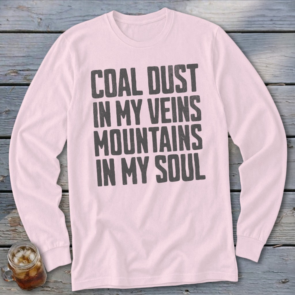 A light pink long-sleeve t-shirt with the dark text COAL DUST IN MY VEINS MOUNTAINS IN MY SOUL printed on the chest.