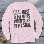 A light pink long-sleeve t-shirt with the dark text COAL DUST IN MY VEINS MOUNTAINS IN MY SOUL printed on the chest.