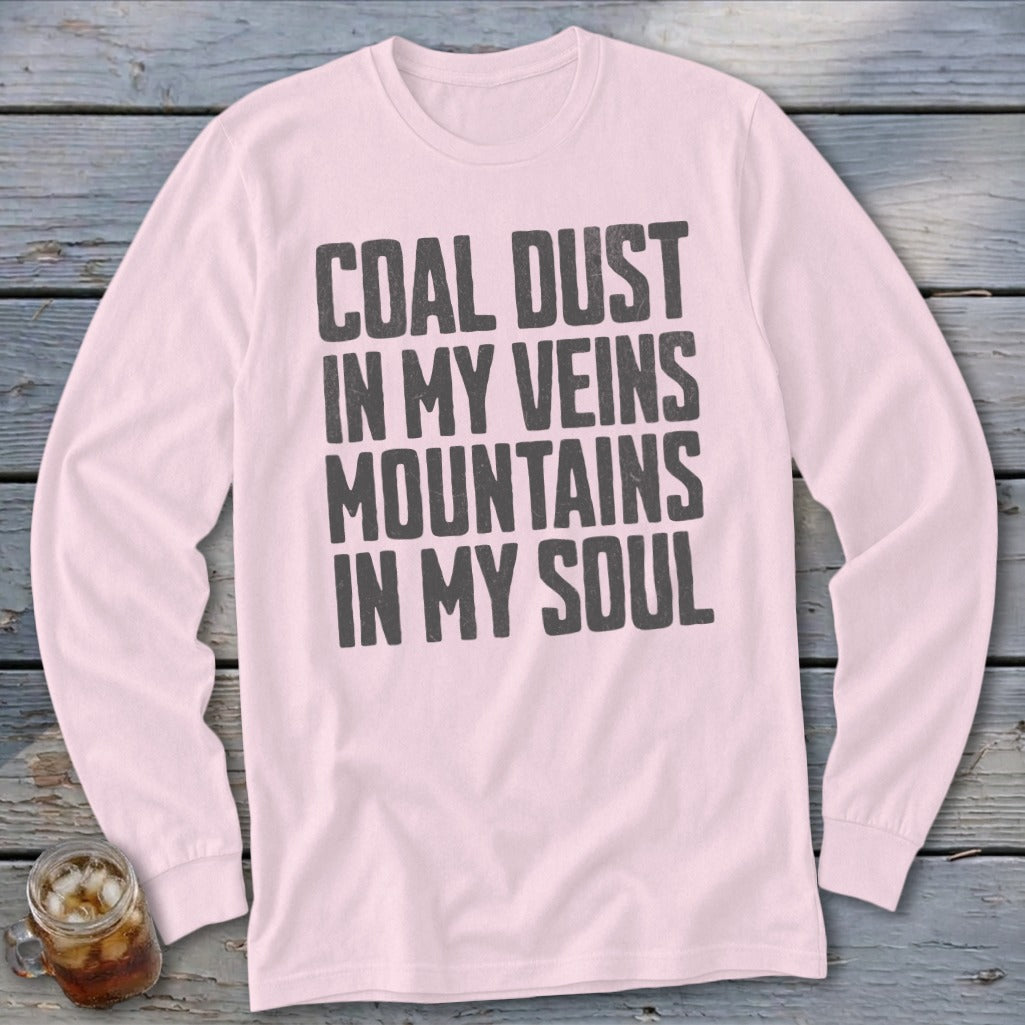 A light pink long-sleeve t-shirt with the dark text COAL DUST IN MY VEINS MOUNTAINS IN MY SOUL printed on the chest.