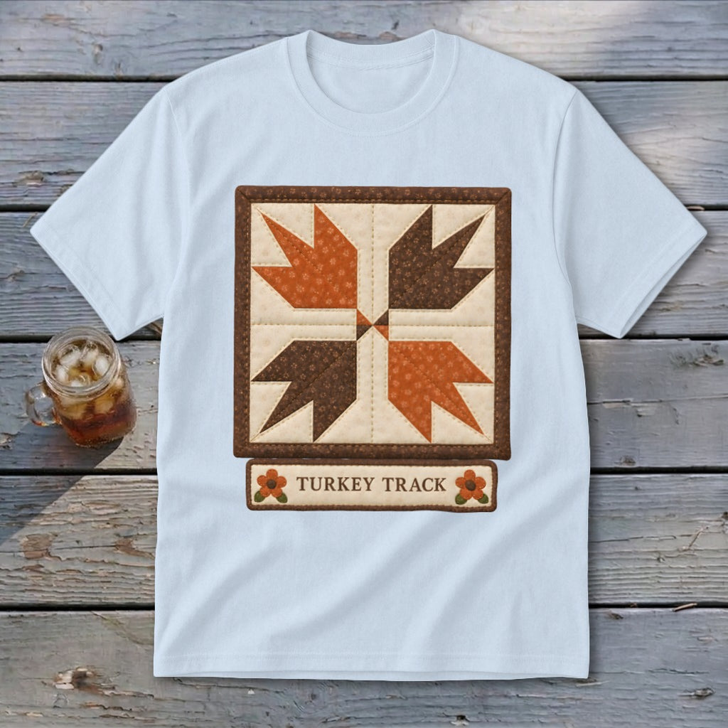 Light blue t-shirt with a "Turkey Track" quilt design and beverage in a mason jar.